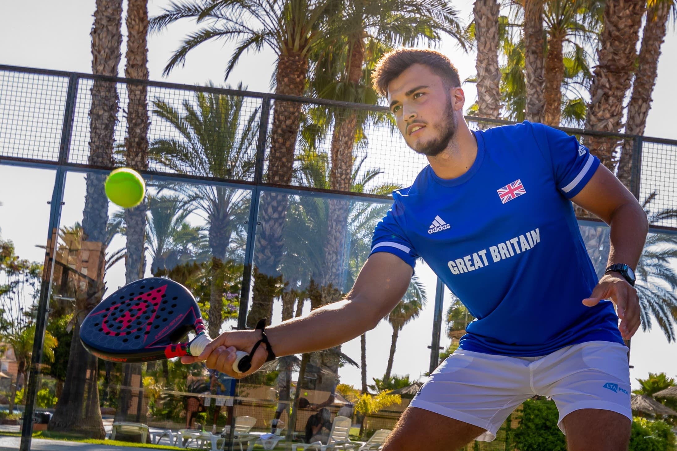 Louie Harris playing padel for Great Britain on an outdoor court