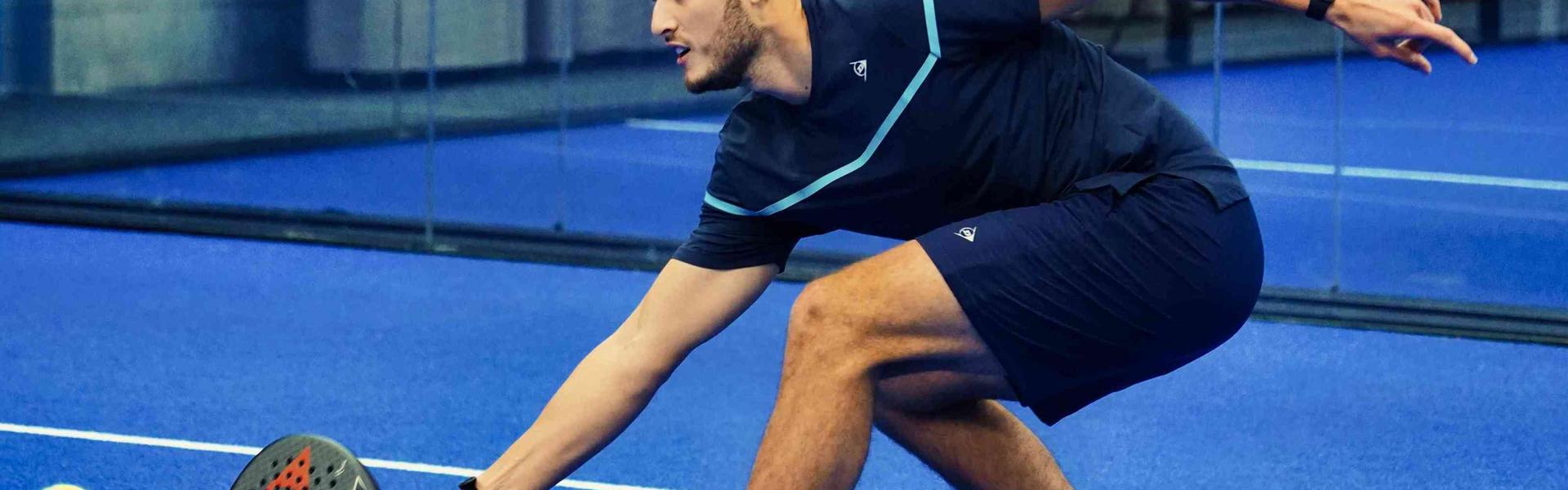 Louie Harris reaching for a padel ball on court