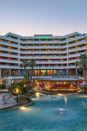 Megasaray Resort Side hotel and landscaped courtyard at dusk.