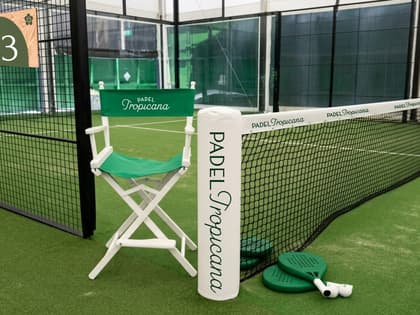 Brand deck mock-up of a green courtside chair, net and rackets beside a green Padel Tropicana padel court.
