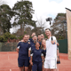 Tennis group selfie on a clay court, a player holds a selfie stick between two Active Away flags.