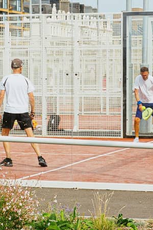 Players competing on an outdoor padel court at Hove Beach Park in Brighton.