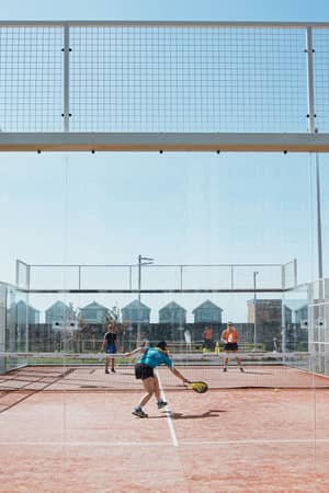 Four players competing on a padel court at Hove Beach Park in Brighton.