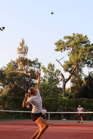 Liberty Lykia player serving on clay