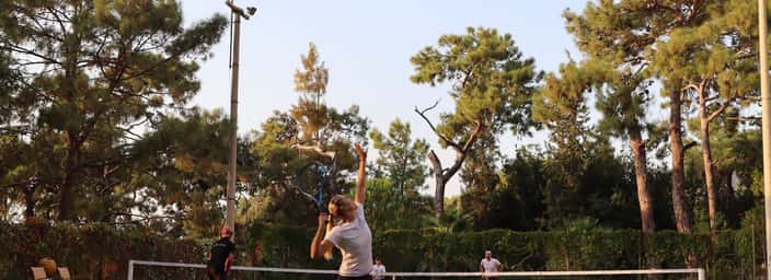 Liberty Lykia player serving on clay