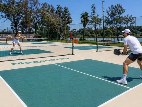 Two players rally on the branded outdoor pickleball courts at Megasaray Resort Side beside Titreyengöl.