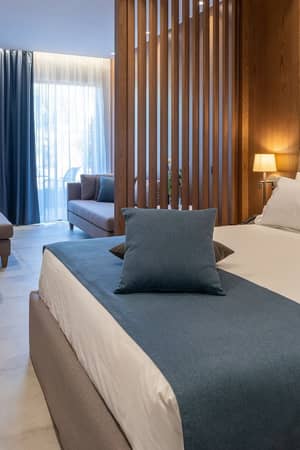 Bright deluxe room at Nana Golden Beach with a double bed, sofa and private terrace.