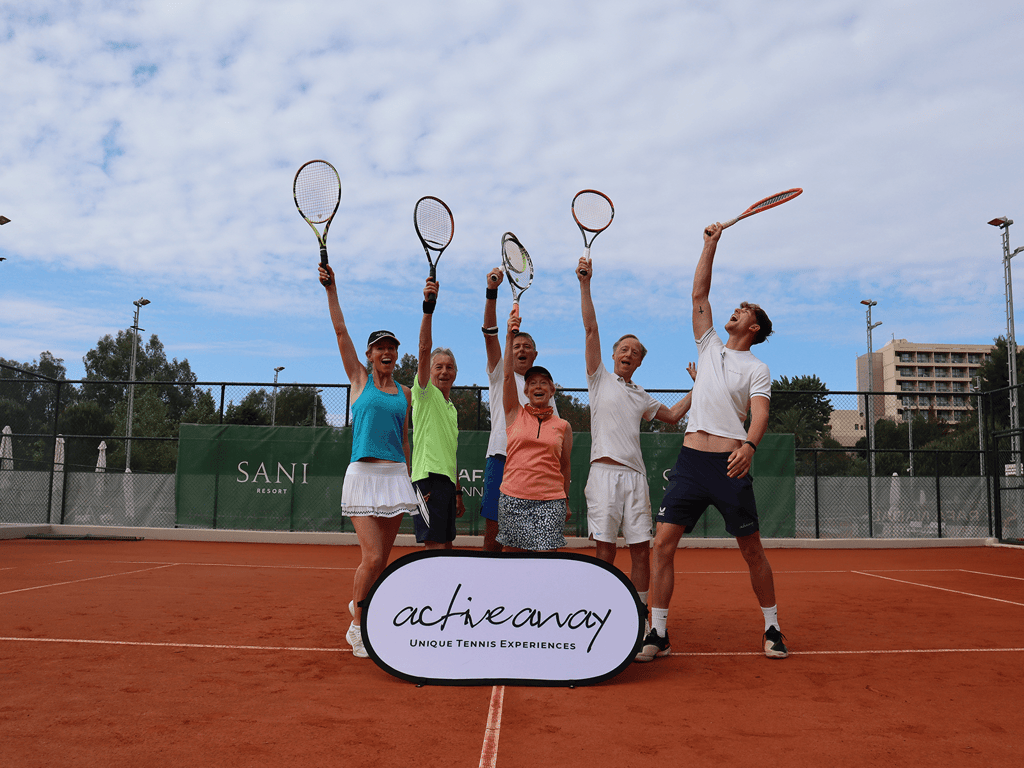 Group of adults celebrating on a clay tennis court, lifting racquets beside an Active Away sign at Sani Resort.