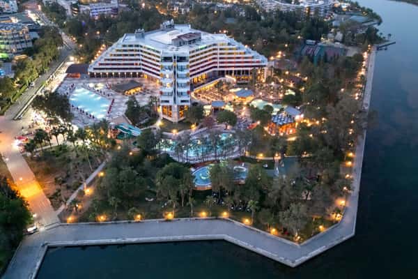 Aerial view of Megasaray Resort Side illuminated at dusk beside Titreyengöl.