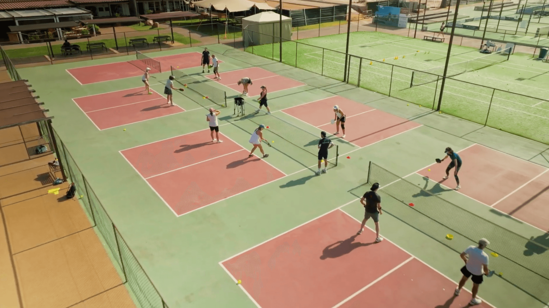 Aerial view of multiple pickleball courts with players doing drills during a holiday clinic.