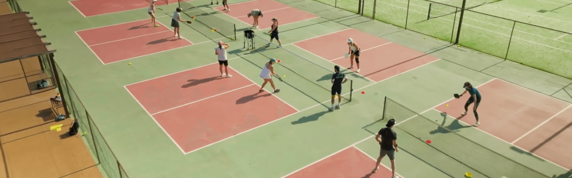 Aerial view of multiple pickleball courts with players doing drills during a holiday clinic.