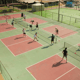 Aerial view of multiple pickleball courts with players doing drills during a holiday clinic.