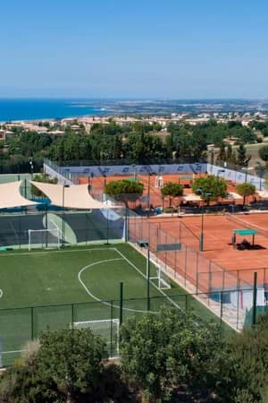 Panoramic view of Aphrodite Hills tennis courts in Cyprus, featuring artificial turf and clay courts with the Mediterranean Sea in the background.