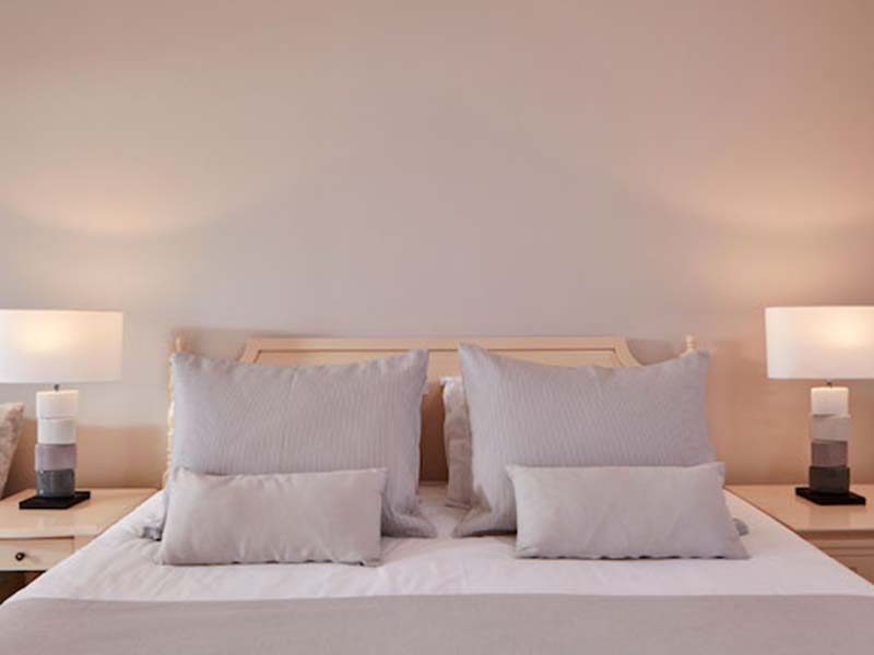 Deluxe double room at Aphrodite Hills with a king-sized bed, plush pillows, and bedside tables with lamps.