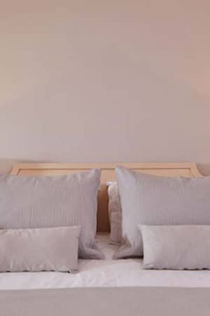 Deluxe double room at Aphrodite Hills with a king-sized bed, plush pillows, and bedside tables with lamps.