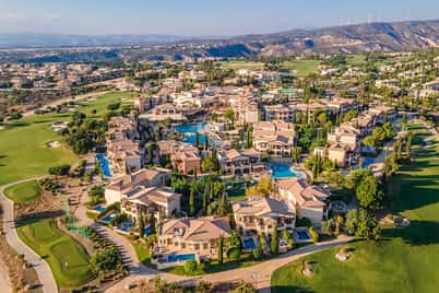 Aerial view of Aphrodite Hills resort in Cyprus, featuring tennis courts and Mediterranean landscape.