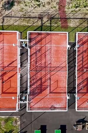 Aerial view of three orange padel courts with players, surrounded by greenery, during a tennis padel weekend in Brighton.