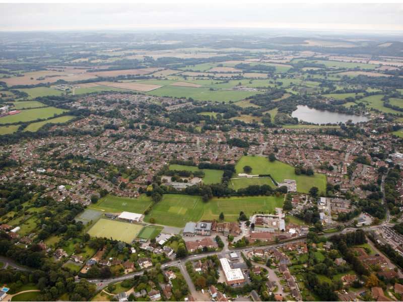 Aerial view of Churcher's College in Petersfield, featuring sports fields, tennis courts, and the surrounding residential areas.