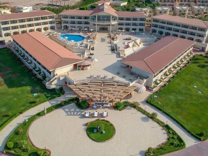 Aerial view of Cleopatra Gallery, showcasing a resort with terracotta-roofed buildings, central swimming pool, and landscaped gardens.
