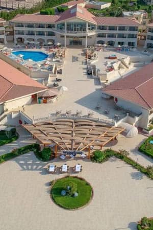 Aerial view of Cleopatra Gallery, showcasing a resort with terracotta-roofed buildings, central swimming pool, and landscaped gardens.
