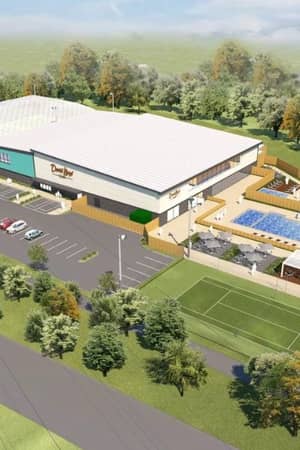 Aerial view of David Lloyd Centre Bristol showing pickleball courts, a swimming pool, and parking, set amidst surrounding trees.