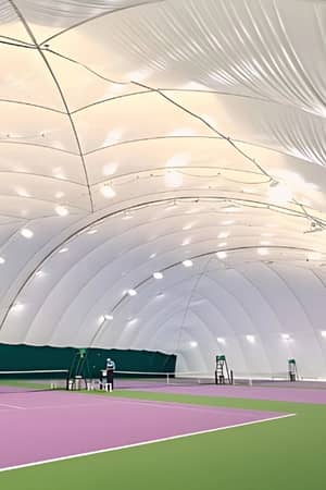 Indoor tennis court at DL Woking with a large inflated dome ceiling and green and purple flooring.