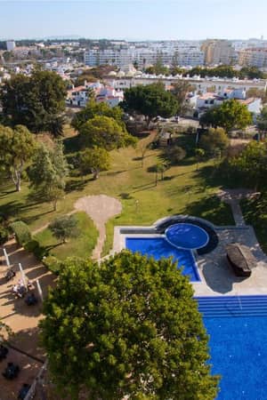 Aerial view of Dom Pedro Gallery pool with surrounding gardens and urban backdrop.