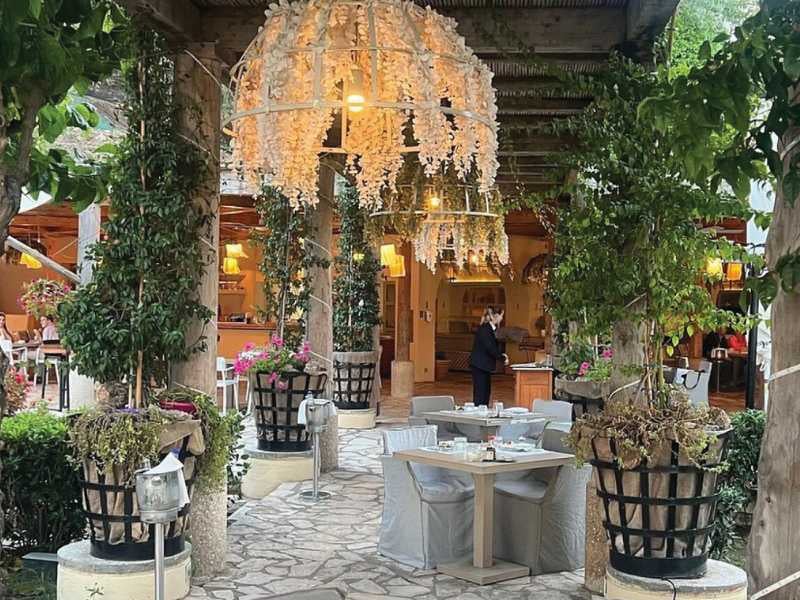 Al fresco dining area at Daphnila Bay with white flower decorations and greenery.