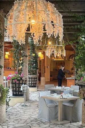 Al fresco dining area at Daphnila Bay with white flower decorations and greenery.