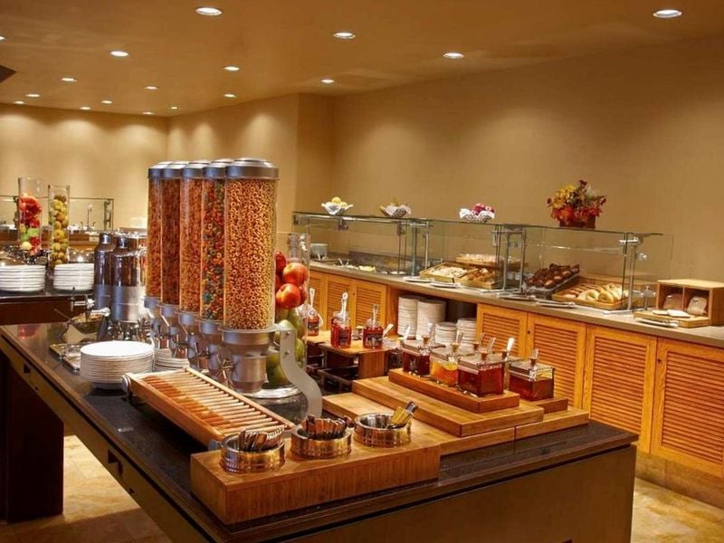 El Conquistador Gallery breakfast buffet with cereals, fruits, pastries, and jams on display in an elegant dining setup.