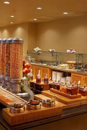 El Conquistador Gallery breakfast buffet with cereals, fruits, pastries, and jams on display in an elegant dining setup.