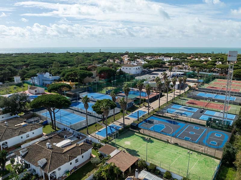 Aerial view of tennis courts at Hotel Vincci Costa Golf with ocean in the background.