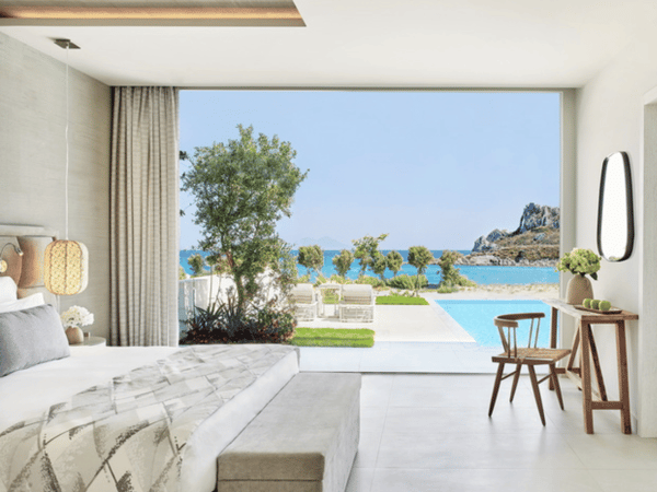 Deluxe One Bedroom Bungalow Suite at Ikos Aria with private pool, sea view, and modern interior featuring a king-sized bed and large window.