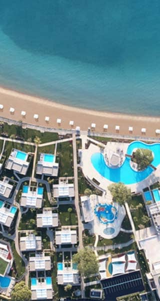 Aerial view of Ikos Dassia resort, showcasing swimming pools, gardens, and Dassia Beach on the Ionian Sea.