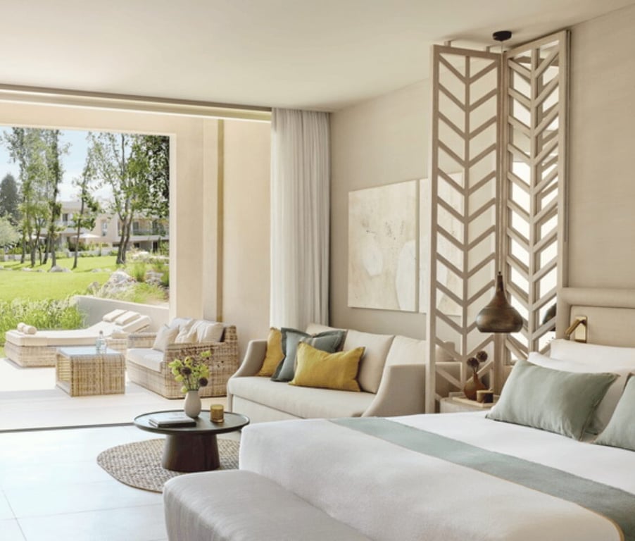 Ikos Odisia Deluxe Junior Bungalow Suite featuring stylish decor and a view of the private garden.