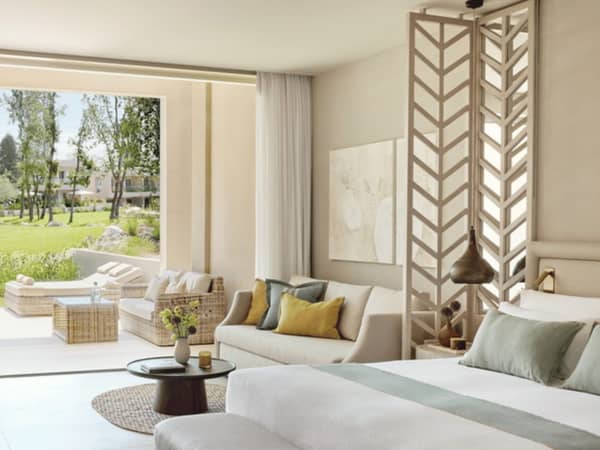 Ikos Odisia Deluxe Junior Bungalow Suite featuring stylish decor and a view of the private garden.