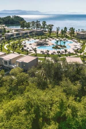 Aerial view of Ikos Odisia resort featuring a circular layout with central pool, lush greenery, and coastal surroundings.