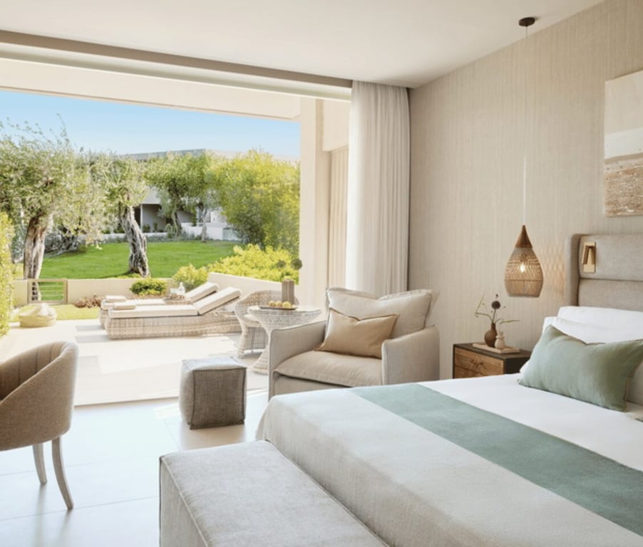 Ikos Odisia Superior Private Garden room with bed, seating, and garden view.
