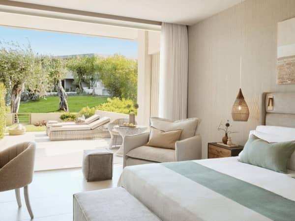 Ikos Odisia Superior Private Garden room with bed, seating, and garden view.