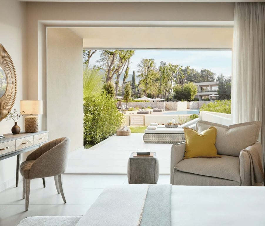 Ikos Odisia hotel room with modern decor, large opening to private garden and pool view.
