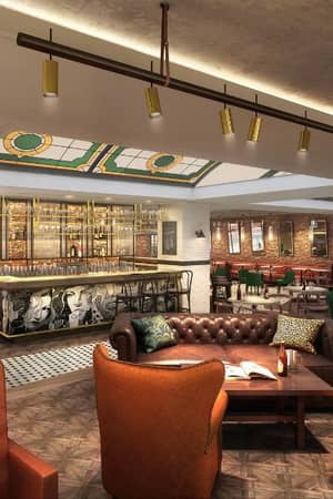 Interior of a trendy bar lounge with leather seating, modern bar, illuminated bottle shelves, and a mix of contemporary and classic design elements.