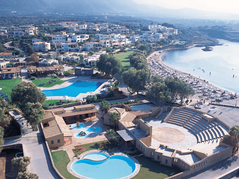 Aerial view of Kalimera Kriti Hotel & Village Resort, featuring pools, open-air theatre, and a beachside location in Crete.