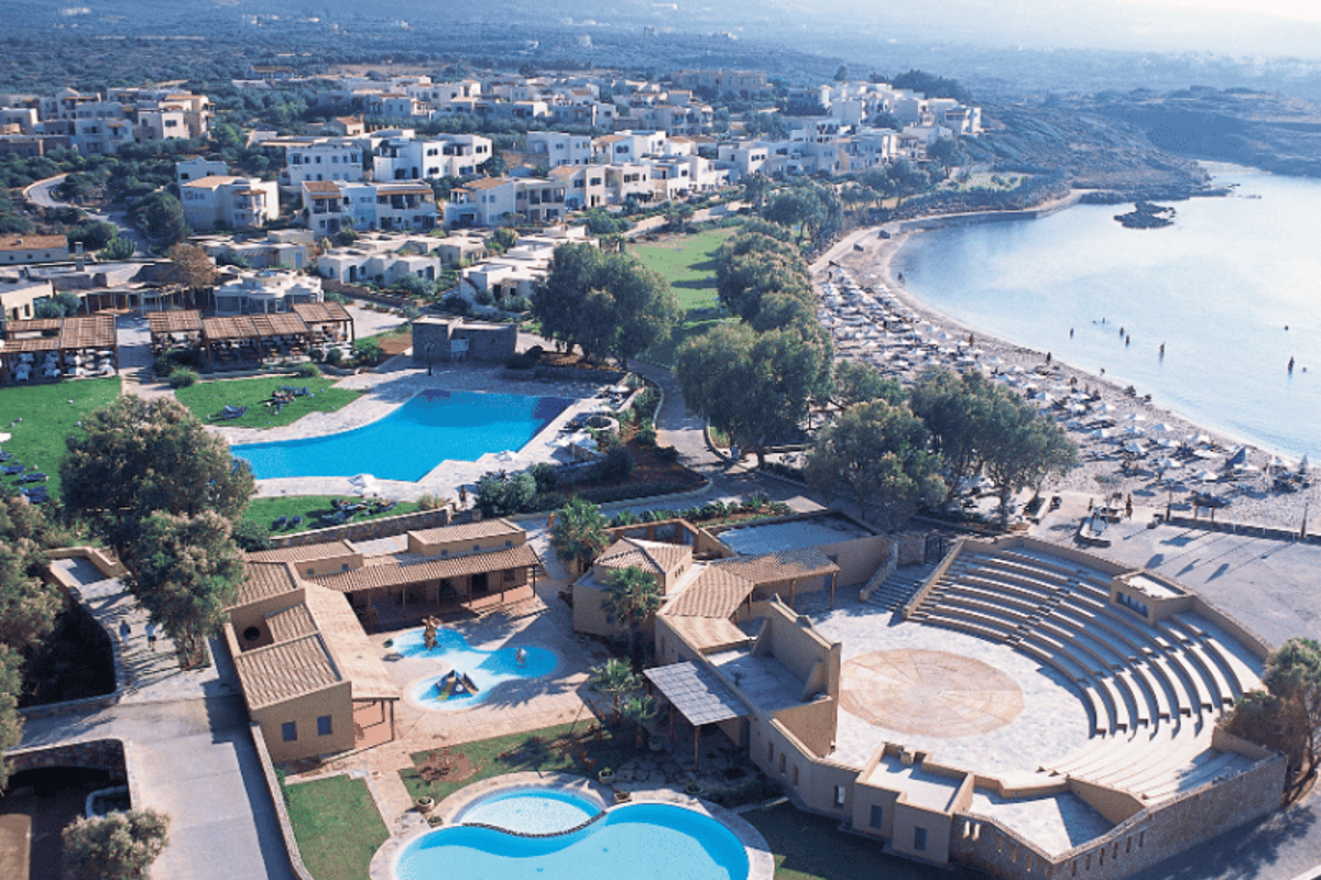 Aerial view of Kalimera Kriti Hotel & Village Resort, featuring pools, open-air theatre, and a beachside location in Crete.