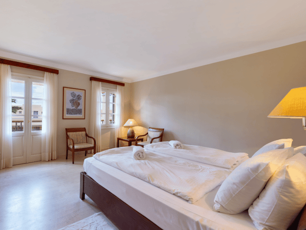 Hotel room at Kalimera Kriti with double bed, wooden furniture, and large windows offering a mountain view.