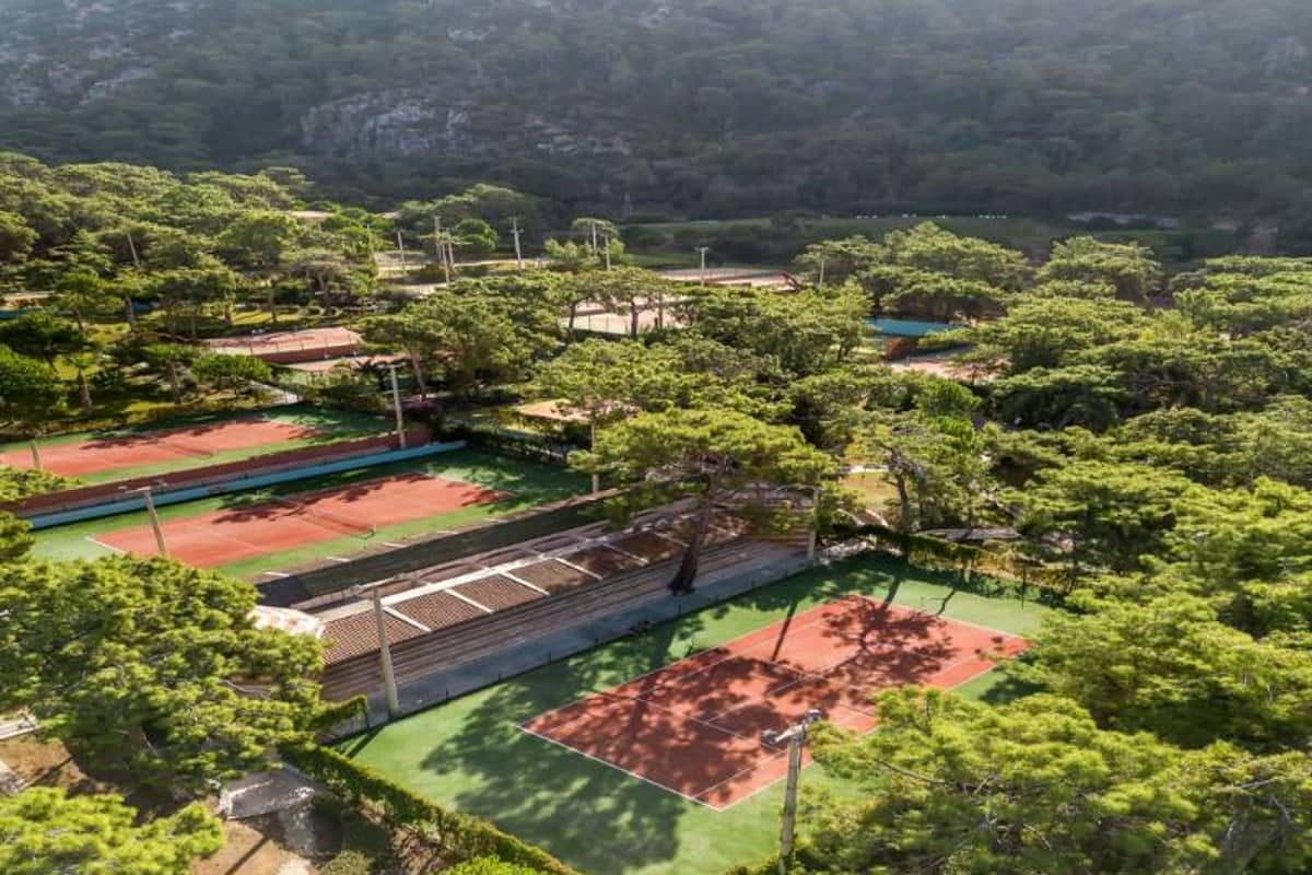 Aerial view of Liberty Lykia Family resort tennis courts surrounded by greenery and pine trees.