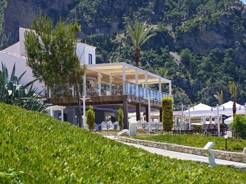 Outdoor restaurant at Liberty Lykia Family resort with scenic mountain views and lush greenery.
