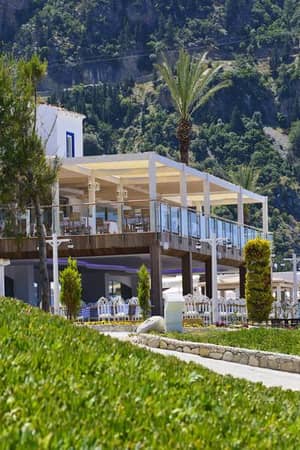 Outdoor restaurant at Liberty Lykia Family resort with scenic mountain views and lush greenery.