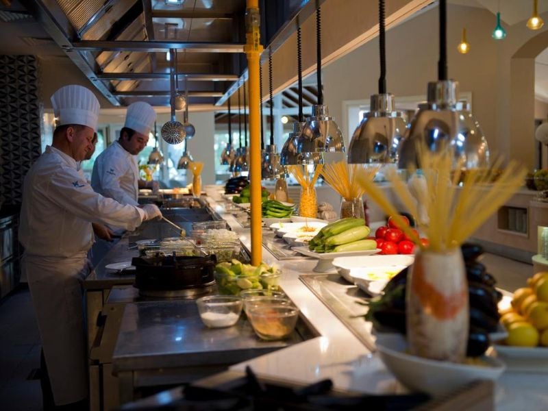 Two chefs preparing meals with fresh ingredients in a modern kitchen at Liberty Lykia.