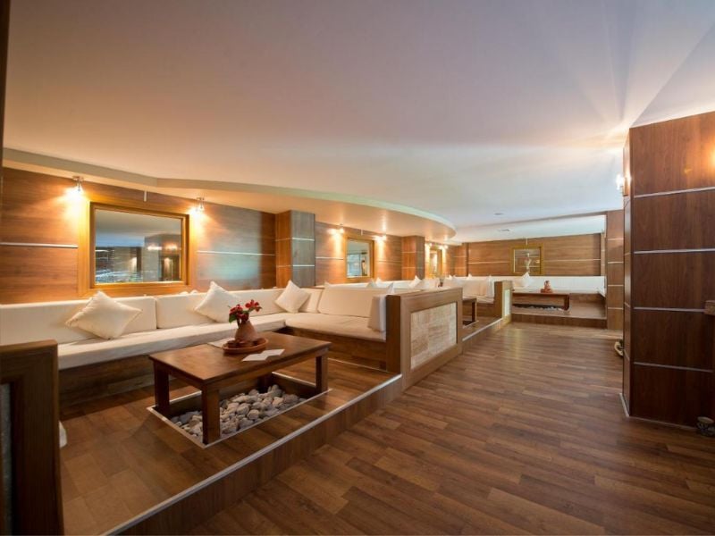 Lounge area at Liberty Lykia with cream sofas, wooden flooring and tables, creating a warm and inviting atmosphere.