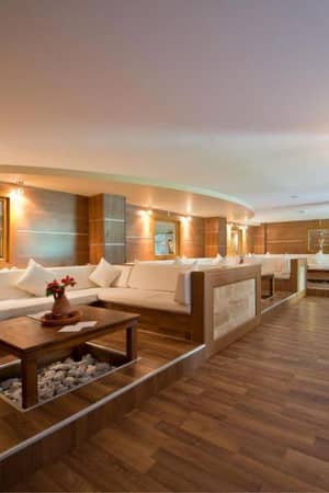 Lounge area at Liberty Lykia with cream sofas, wooden flooring and tables, creating a warm and inviting atmosphere.